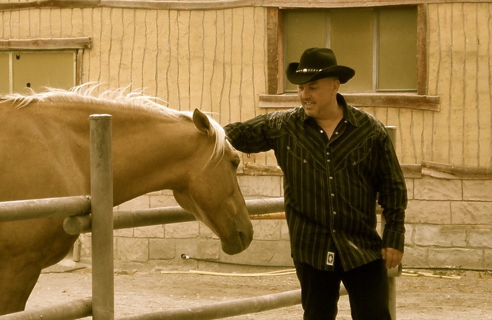 Hombre acariciando un caballo
