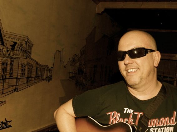Hombre jugando guitarra sonriendo